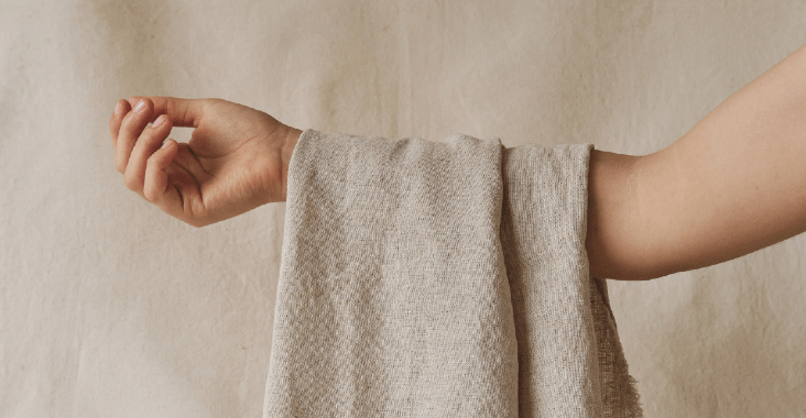 An arm holding a cream linen cloth